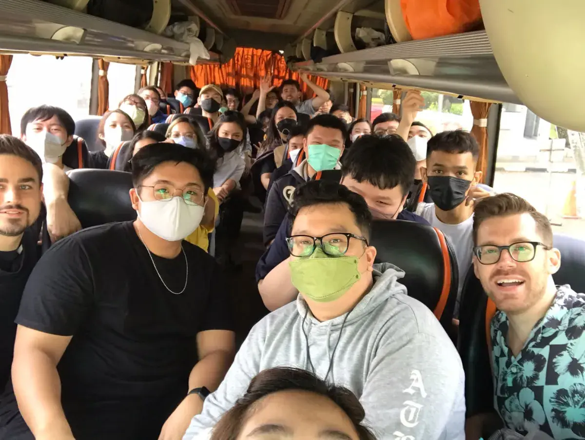 Kodefox teammates packed into a bus, most wearing face masks, smiling at the camera